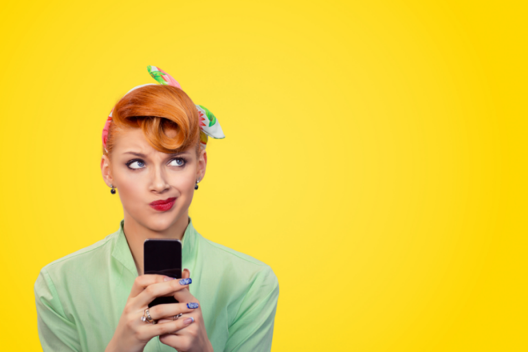 A woman holding a smartphone and looking up, yellow background