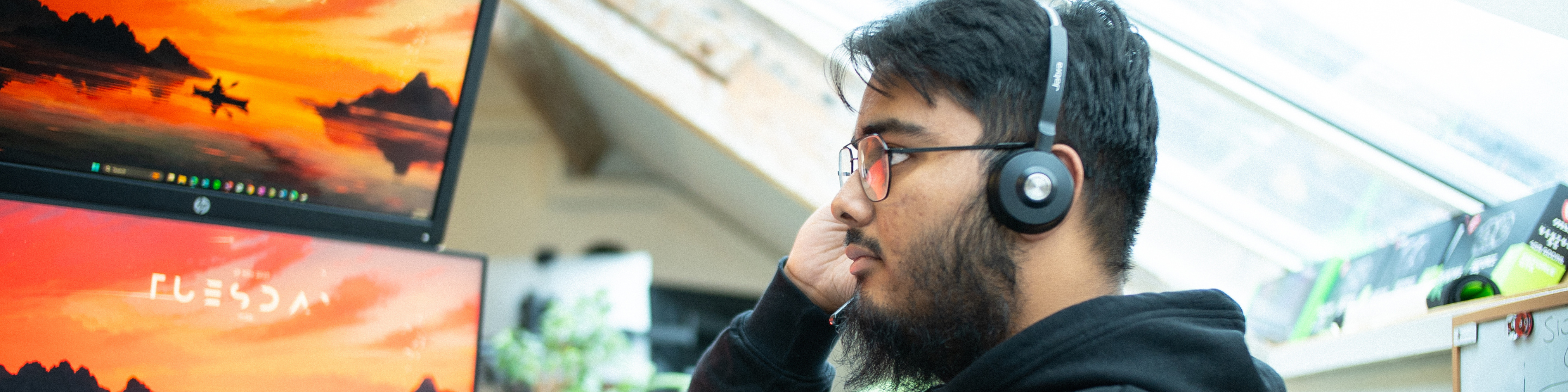 Syed working infront of multiple computer screens