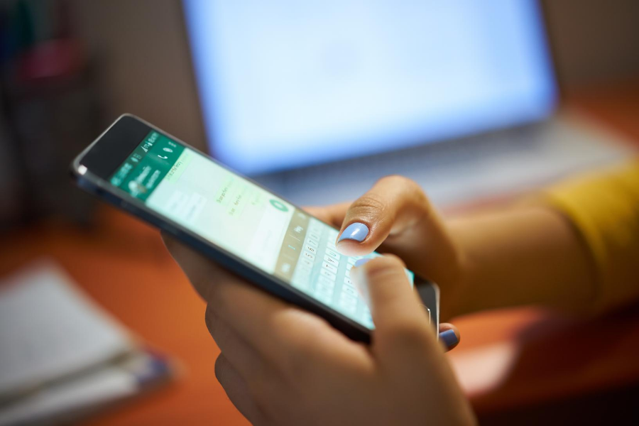 smartphone with WhatsApp open in woman's hands