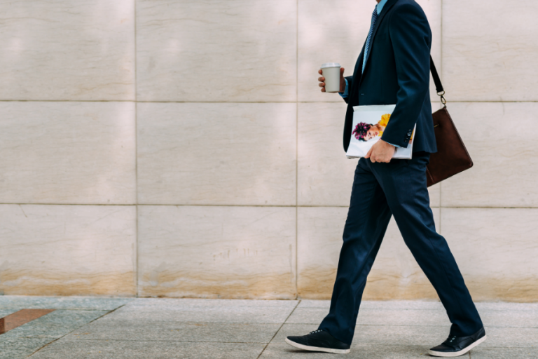 a picture of man walking with a coffee and briefcase