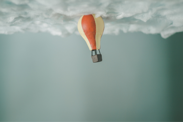 a hot air baloon right under the clouds