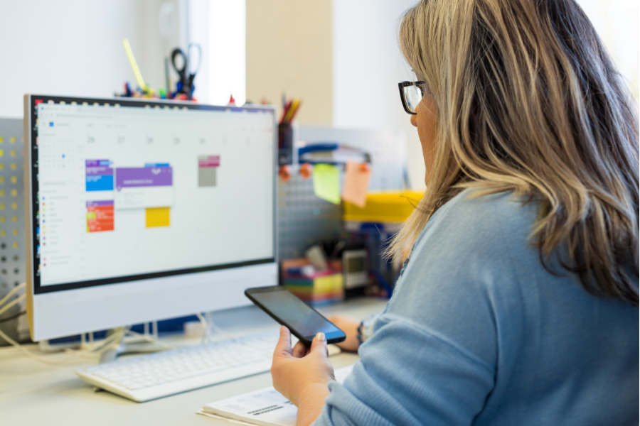 Woman using Google Workspace tools on a desktop computer in an office setting