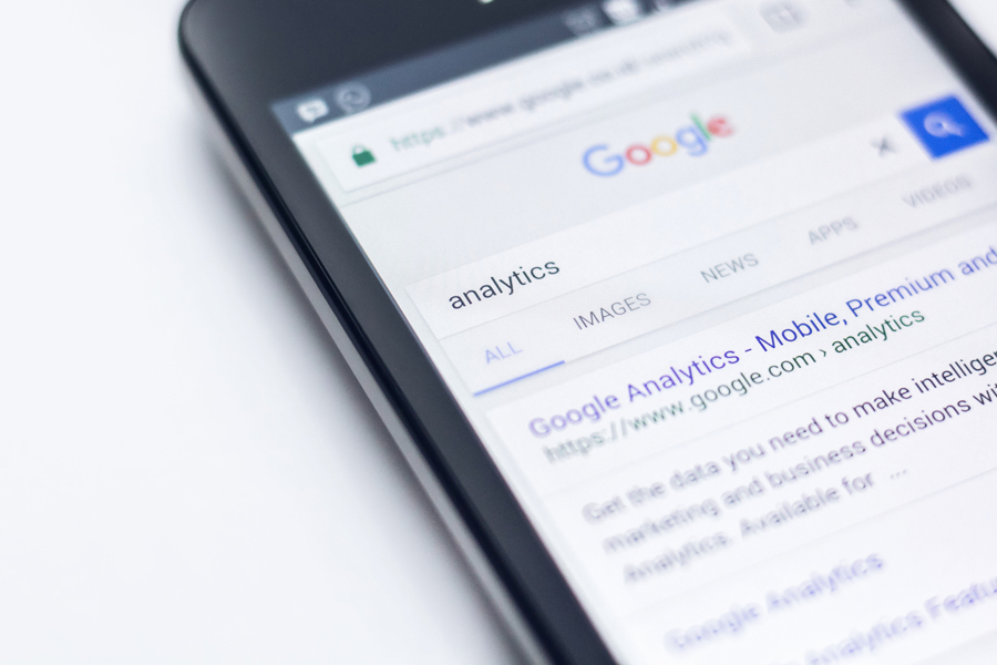 A mobile phone with a google search for google analytics open on the screen